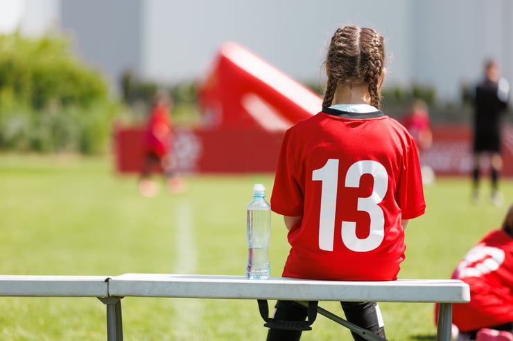 Girl Wearing Number 13 Jersey Sitting on Bench. Girl Soccer Player Resting on Sideline Bench