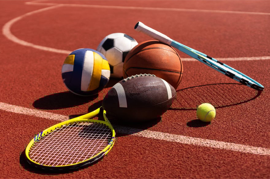 A collection of sports equipment sitting on a track. 