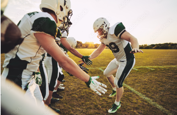 Youth football players practicing teamwork drills showing leadership skills development on field